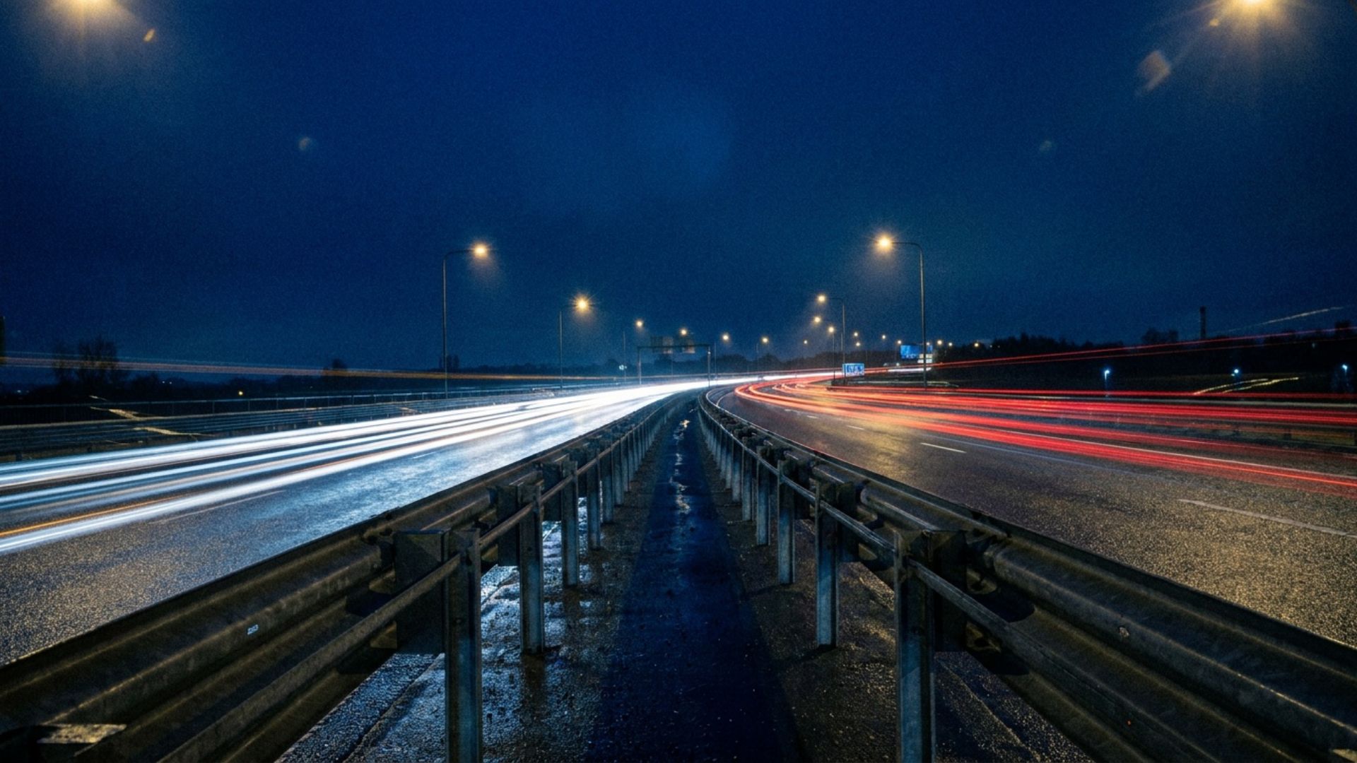 A night highway with guardrails and fast light trails